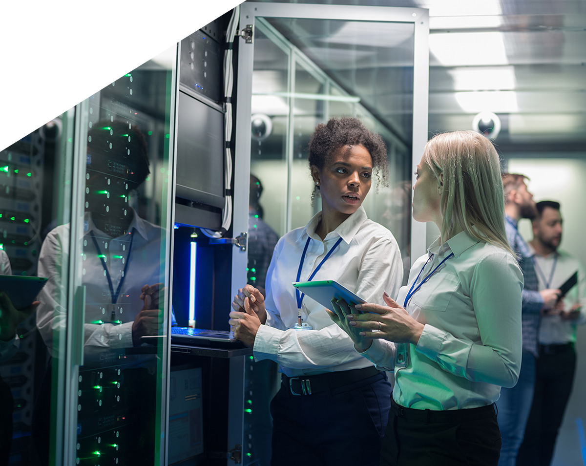 Two-women-are-working-in-a-data-center-with-rows-of-server-racks